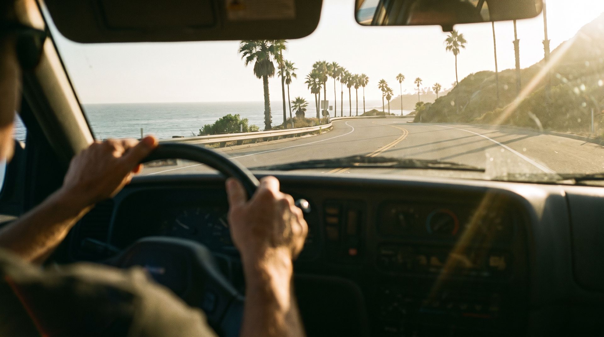 Driver's hands on the wheel on a Southern California coastal highway